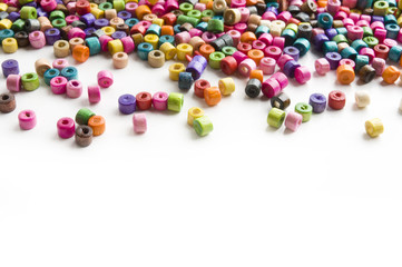 Colorful wooden beads scattered on white