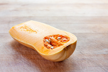 Butternut squash cut in half on a wooden board