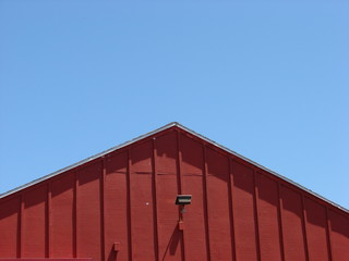 Red barn roof against blue sky