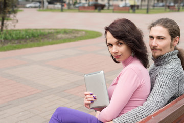 Trendy young students couple in town using tablet