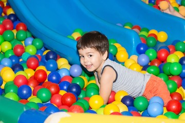 Fototapeta na wymiar Мальчик играется в разноцветных шариках