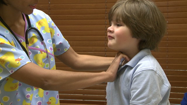 Nurse checks young child's glands