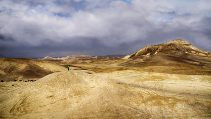 Photographer on hill top in a desert