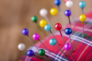 macro colored sewing pins in scottish pincushion