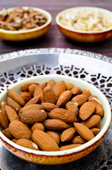 Assorted nuts in dishes on wooden table