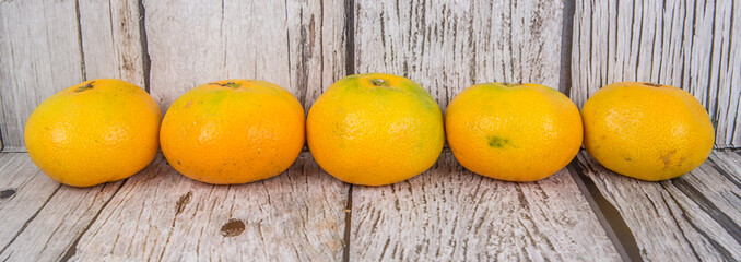 Yellow tangerine fruit over wooden background