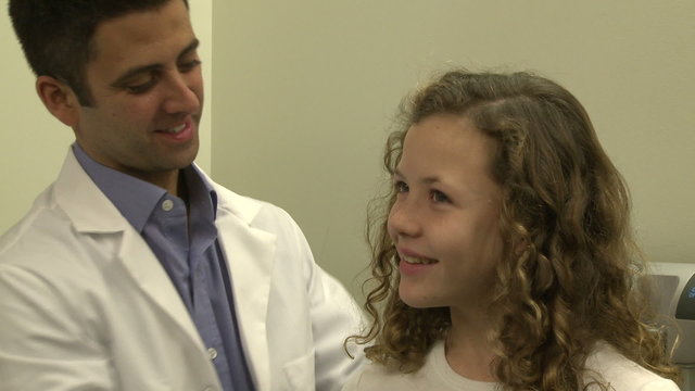 Doctor measures height of teenage patient
