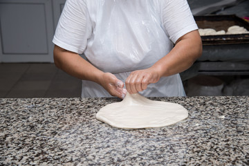 close up of female hands kneading dough and making banitsa