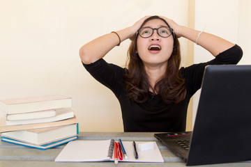 Young woman tired of working, doing homework, with notebook and laptop