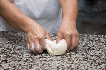 close up of female hands kneading dough and making banitsa