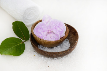 Fototapeta na wymiar Orchid with salt in bowl and green leaf on towel