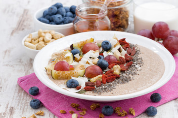 oatmeal with assorted fresh fruits, nuts and chia in plate