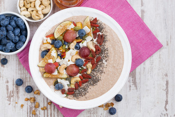oatmeal with assorted fresh fruits, nuts and chia, top view