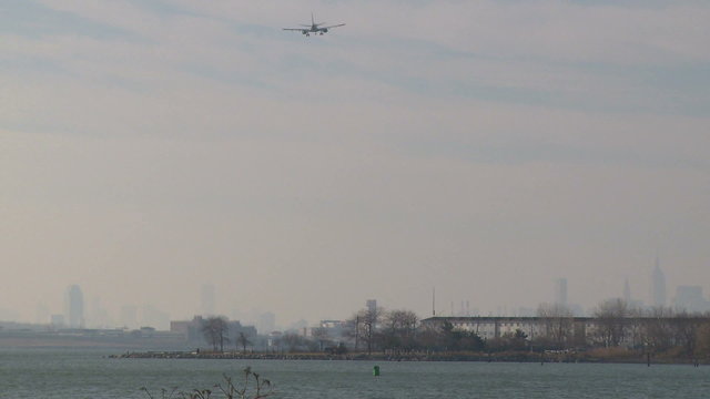 Plane coming in for a landing over the water 