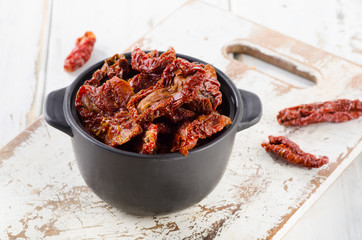 Italian sun dried tomatoes on  white wooden table.
