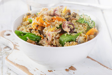 Salad with quinoa and seafood on white plate.