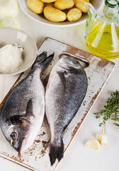 Fresh raw dorado fish on  wooden cutting board.