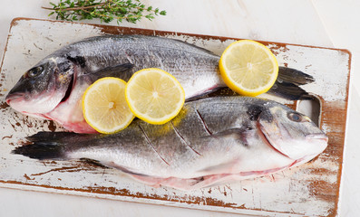 Fresh raw dorado fish on a cutting board.