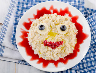 Smiling oatmeal and fresh berries for a breakfast.
