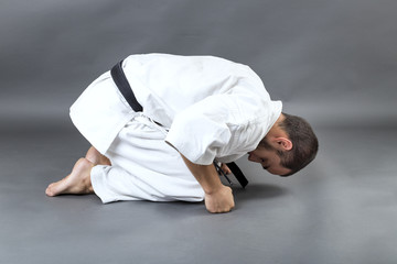 Young fighter in white kimono saluting