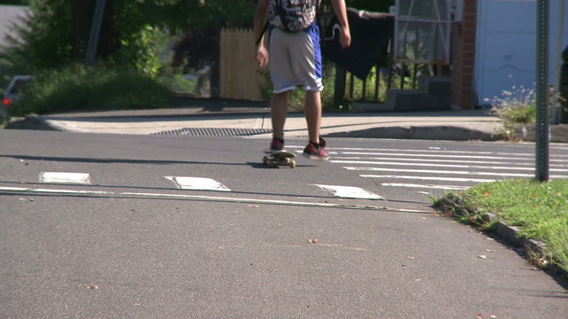Boy going down street on skate board