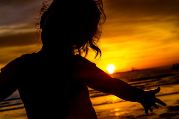 Naklejka na ściany i meble silhouette of happy child on tropical sunset sea background