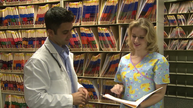 Nurse hands off chart to doctor