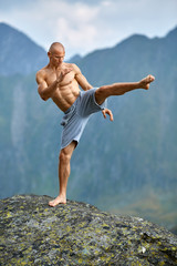 Kickboxer or muay thai fighter training on a mountain cliff