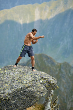 Kickboxer or muay thai fighter training on a mountain cliff