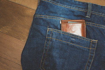 brown leather wallet in jeans back pocket blue