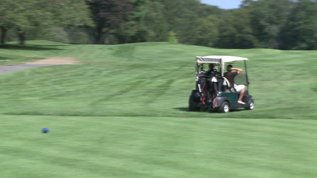 Golf cart driving along course