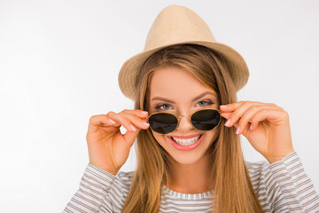Naklejka premium happy girl with a hat putting glasses on her nose