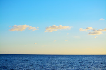 Obraz premium blue sea under a clear sky with small clouds
