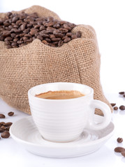 Cup of coffee with a burlap bag filled with coffee beans