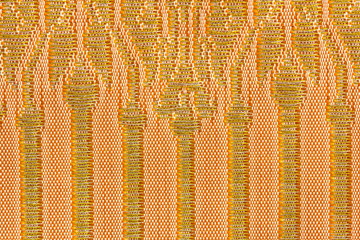 A beautiful piece of very fine Thai silk of golden wand on orange and white background.