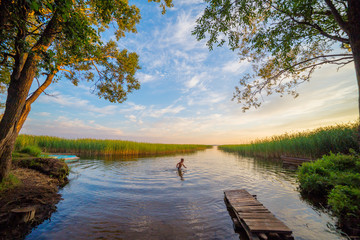 River shore with boy swimming