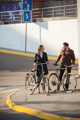 Young couple with on a bicycle opposite city 