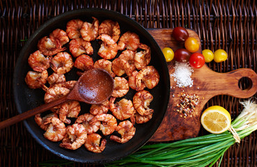 There are shrimps in a cast iron skillet