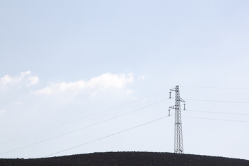 Strommast auf dem Hügel im hintergrund eine Wolke
