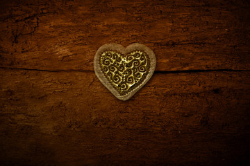 One gold hearts on old wooden background