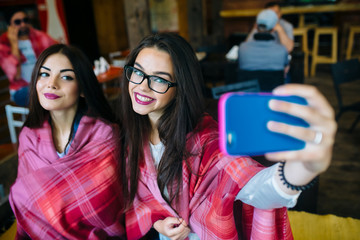 two close friends do selfie in the cafe