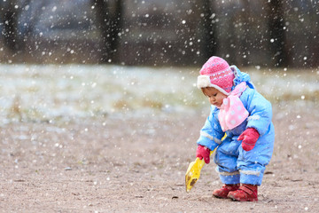 little girl play in snow winter park