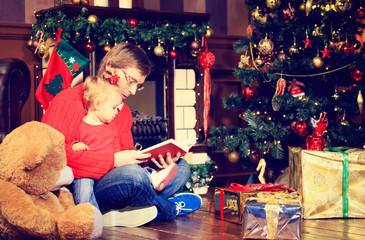 Fototapeta na wymiar father and little daughter reading book in christmas