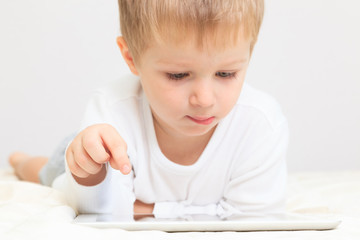 Fototapeta premium Little boy with touch pad, early education