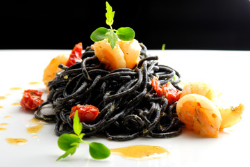 Fine dining, Italian squid ink pasta with shrimp basil selective focus