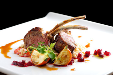 Fine dining roasted Lamb Chops on whole grain rice, mini aubergines and a sauce garnished with...