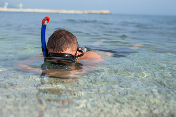 Boy swimming in the sea in mask, and fins
