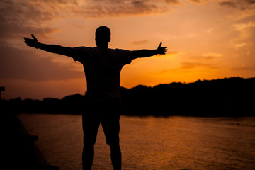 Fototapeta premium A man standing on the background of sunset