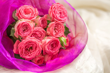 Wedding bouquet of pink roses in a beautiful lilac packaging