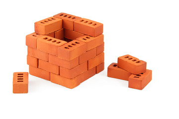 construction toy brick house. construction a brick house of miniature toy bricks, isolated on white background